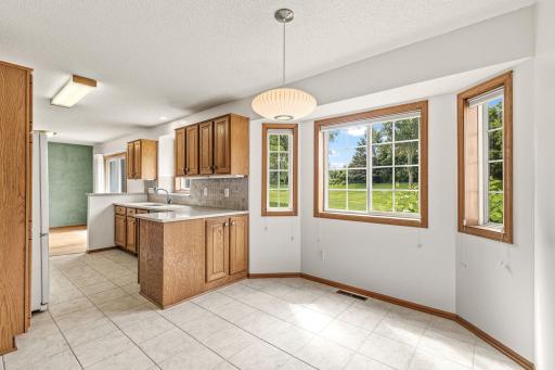 Bright an spacious informal dining area with a picturesque view of a lush and private backyard.