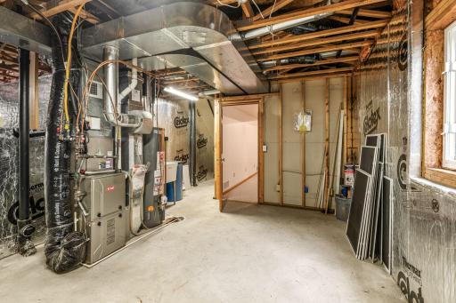 Unfinished mechanical/storage room complete with a laundry sink, egress window, and rough-in for a future 3/4 bath.