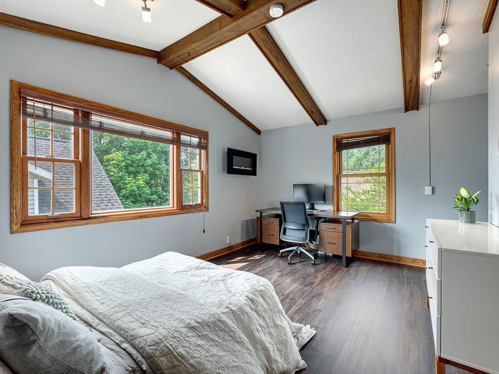 Bright and inviting second bedroom with vaulted ceilings that add character and volume.