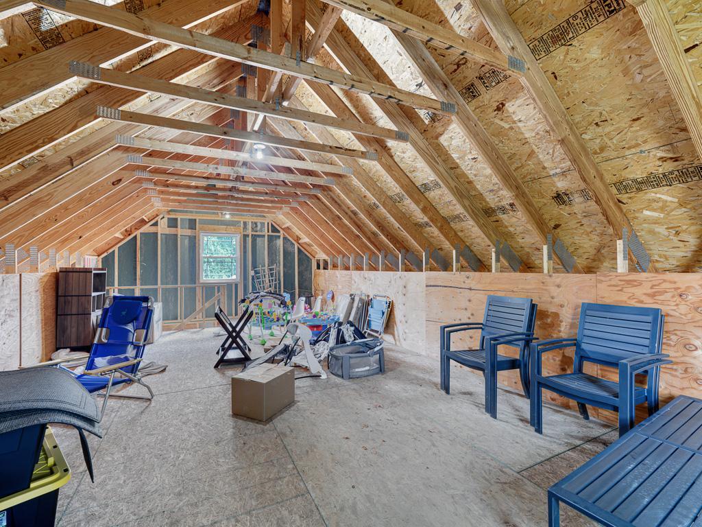 Unfinished loft space offers flexible potential for storage, a creative studio, or future finishing.