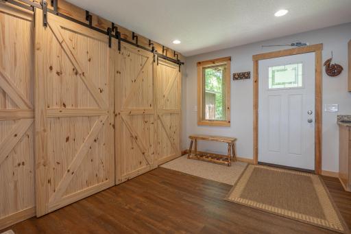 Spacious entryway with barn door storage area and laundry closet