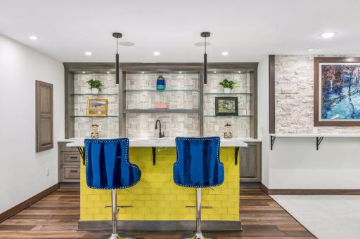 Lower level wet bar with bar counter seating.