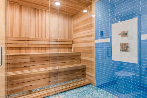 Sauna with tile floor and floor to ceiling tile rain shower.