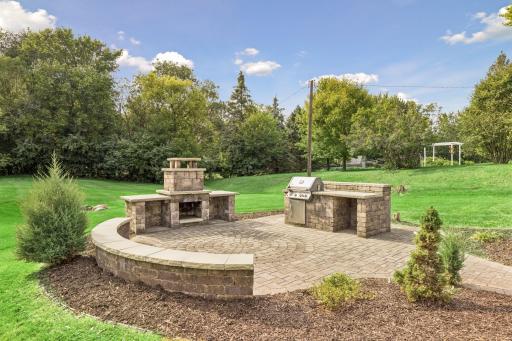 Enjoy entertaining outdoors on the patio with built-in bench, built-in grill, and stone hearth.
