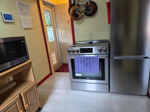 The kitchen is just steps from the back door- great for bringing the groceries in! Notice the doggie door.