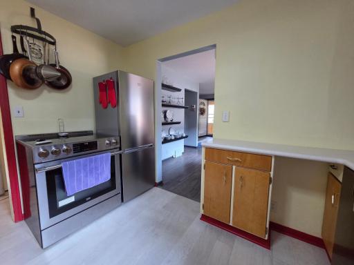 Another view of the kitchen into the dining. New High-End European SS appliances in 2022! Notice the convenient pans hanging overhead.