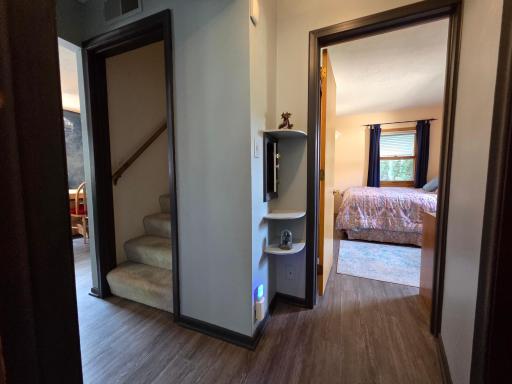 The main hall between the bedrooms, showing the staircase, corner shelves (see the laundry chute door), and the full BA is to the right.