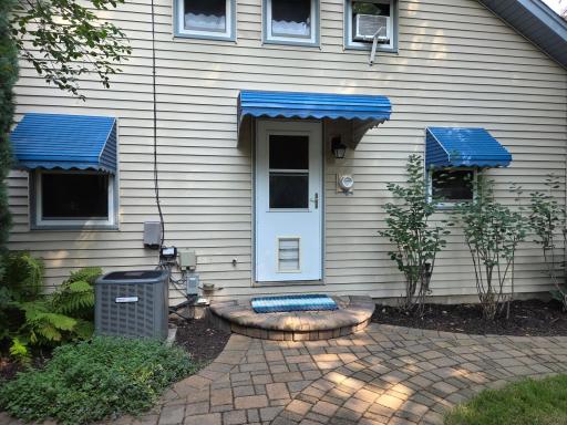 Step out the back door to another 1/2 circle step & down to brick patio. Notice the awnings.
