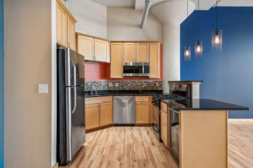Beautifully renovated kitchen with stainless appliances, granite counters & tile backsplash