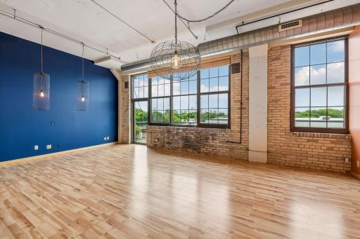 Open concept living/dining area with genuine WOW effect with wall of windows, exposed ductwork and brick details