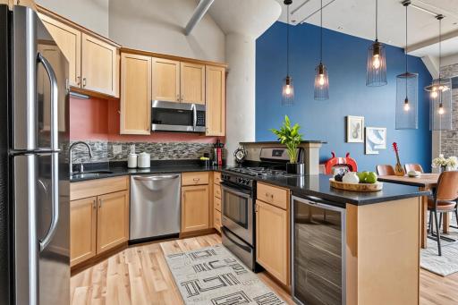 Ample kitchen space with breakfast bar adjacent to dining area. Virtually staged.