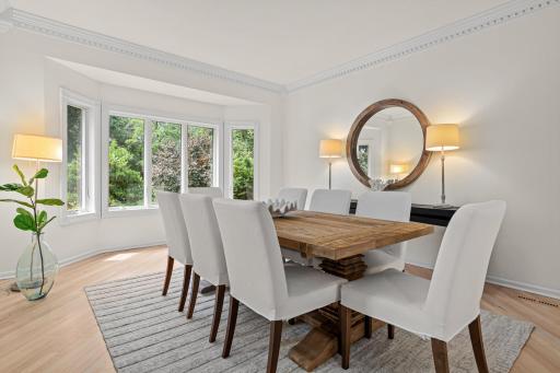 An elegant formal dining room perfectly positioned to capture sweeping views of the golf course-like backyard, creating an unforgettable setting for holiday gatherings and special occasions.