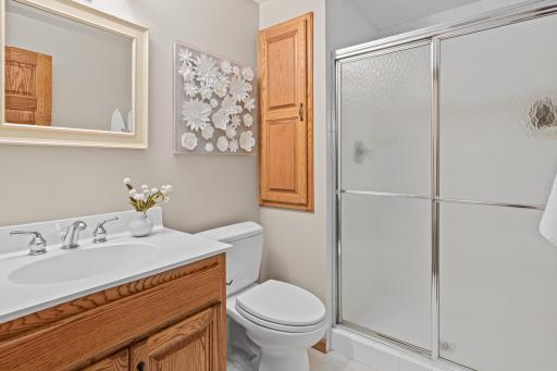 The lower-level 3/4 bathroom is perfect after a day at the lake. Slate tile from the outdoors to this room is both functional and beautiful.