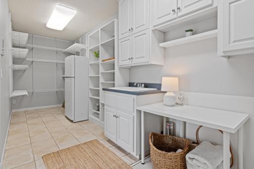 An expansive walk-in pantry and spacious main-floor laundry room provide exceptional storage and everyday convenience, making it easy to organize groceries, lake gear, towels, and all the essentials for effortless lake living.