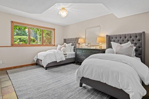 The spacious lower-level bedroom is perfect for guests and includes gorgeous views of the backyard and beautiful perennials.