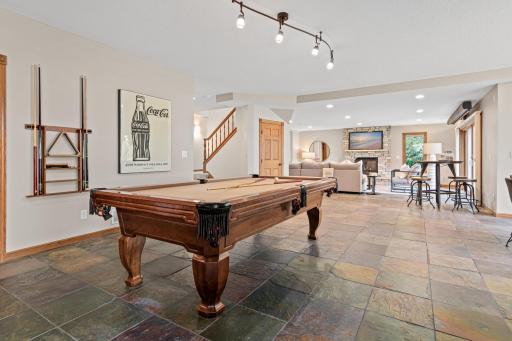 The walk-out lower level is designed for effortless entertaining, featuring a billiards area, custom bar, spacious family room, and private fifth bedroom. Step outside to the expansive paver patio and enjoy breathtaking views of Turtle Lake.