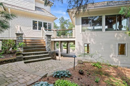 Beautiful paver pathways meander through the estate, winding past gorgeous perennial gardens and connecting multiple outdoor living spaces while providing effortless access to the lakefront.
