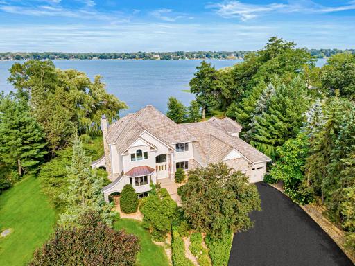 A winding drive leads through the estate's golf course-like grounds, creating a breathtaking approach to the home.