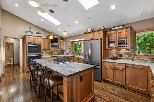Updated kitchen has vaulted ceiling with skylights, custom cabinets, vaulted ceiling with skylights, ceiling fan & stainless steel appliances.
