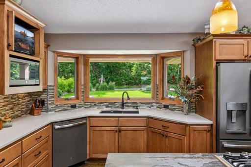 Bay window, quartz countertops & glass tile backsplash.