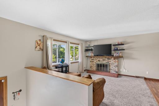 Large windows and a wood-burning fireplace anchor the living room.