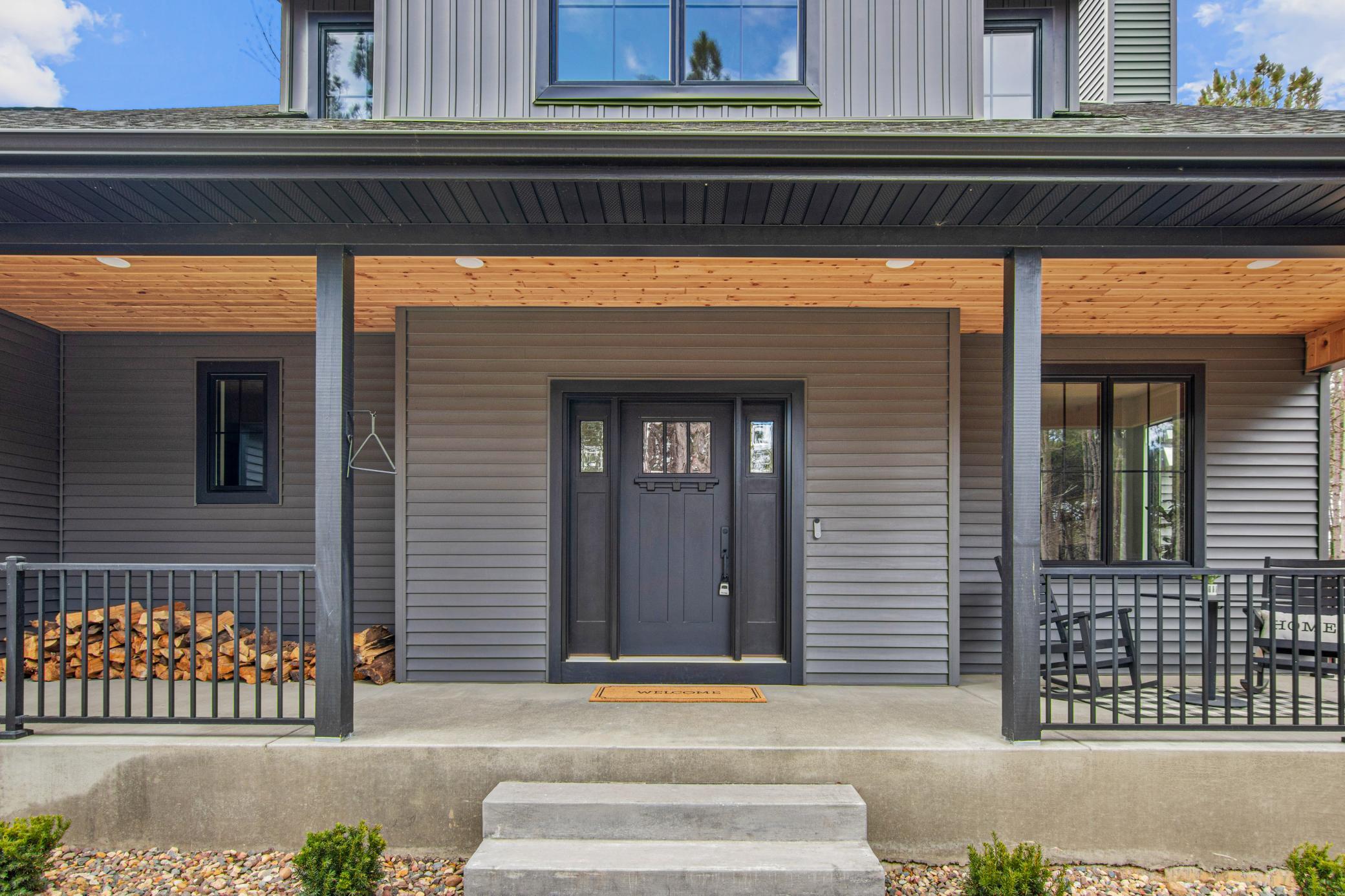 Cedar-lined front porch creates a warm welcome before stepping inside.