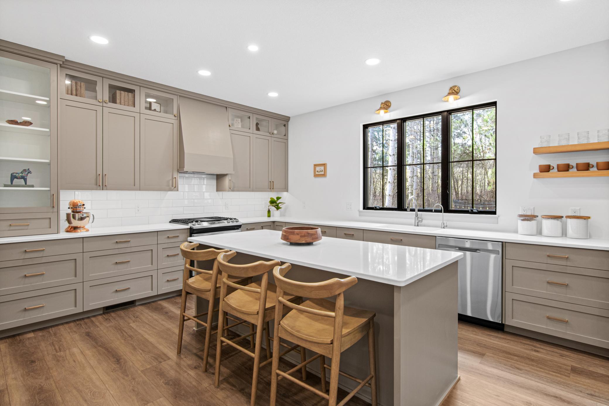 Quartz countertops, a large center island, and abundant kitchen storage anchor the heart of the home.