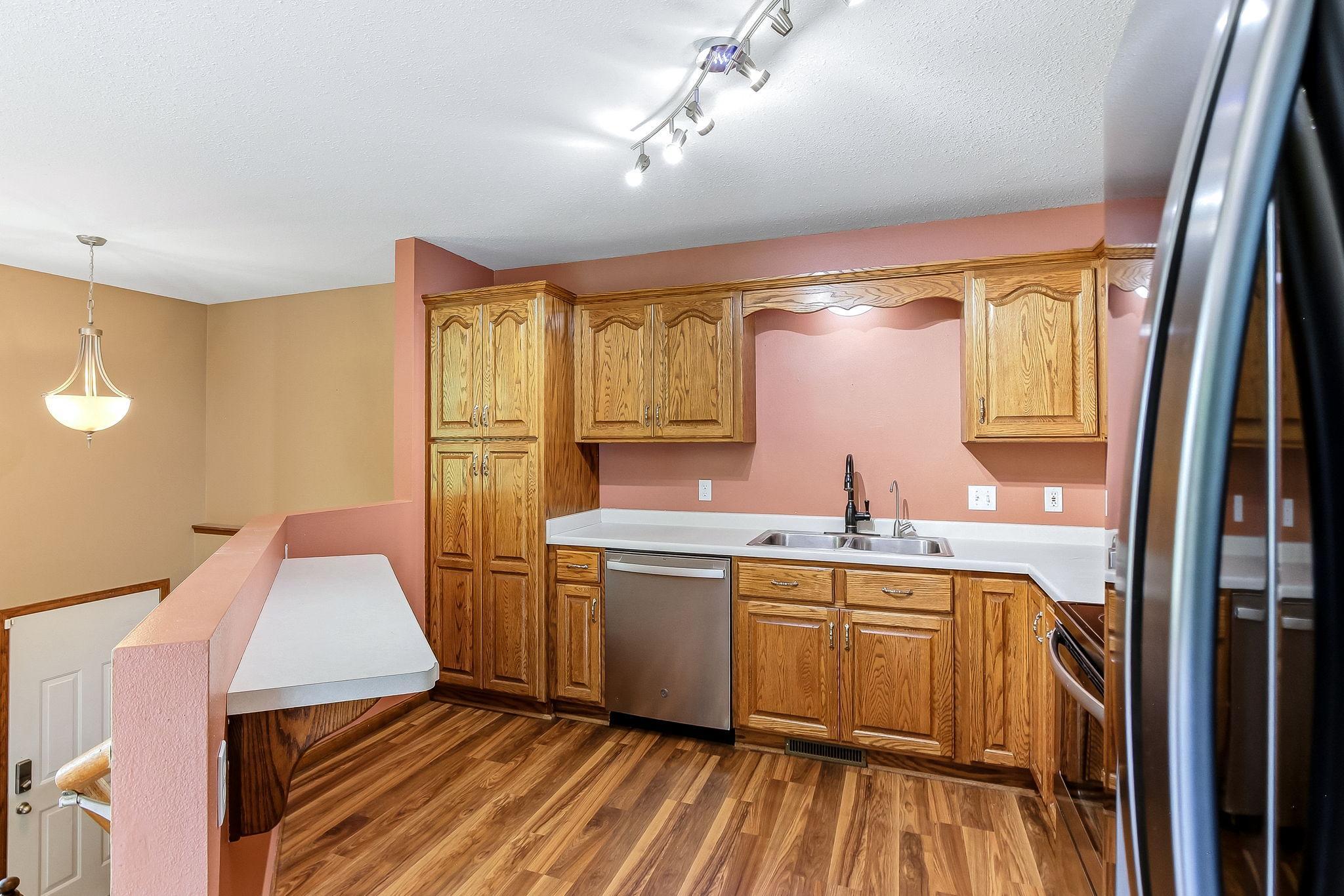 Open-concept kitchen features a convenient breakfast bar for quick bites. The extra counter can also be used for serving food for a buffet style meal or apps. Overlooking the main living areas, it's designed for both functionality and connection.