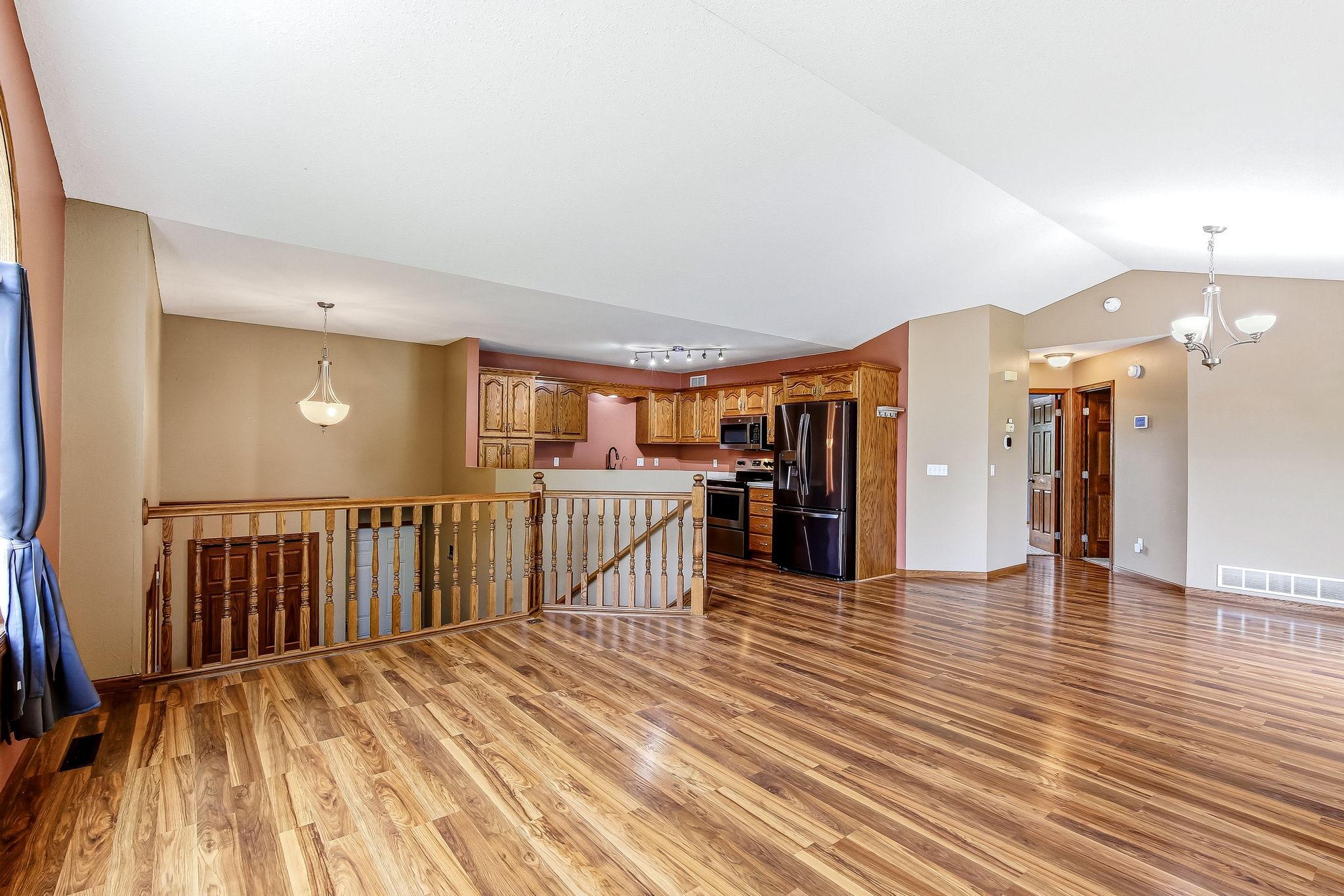 he open-concept layout seamlessly connects the living area to the kitchen, creating an ideal setting for everyday living and entertaining. Warm wood cabinetry, an open railing overlook, and spacious sightlines add character and functionality to this