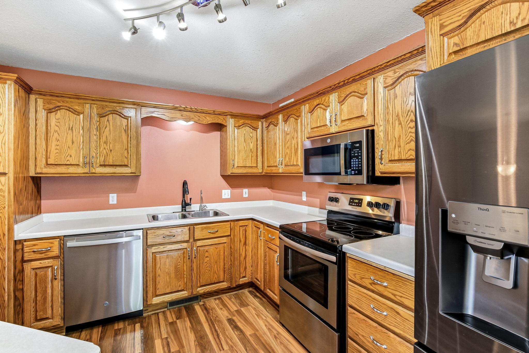 Functional kitchen offering abundant oak cabinetry, ample countertop workspace, and stainless steel appliance efficient layout keeps everything within easy reach, while the double-basin sink makes meal prep and cleanup effortless.