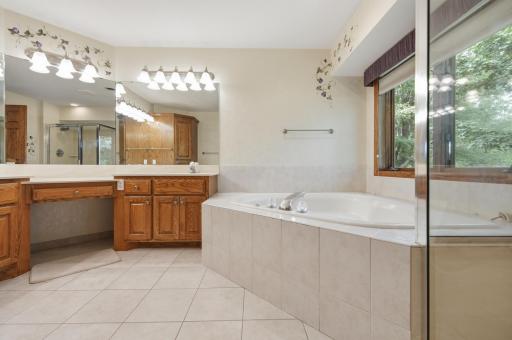 Large private primary bathroom with separate soaker tub and shower