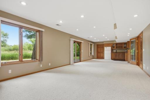 Recessed lighting, walls of windows, and a wet bar.