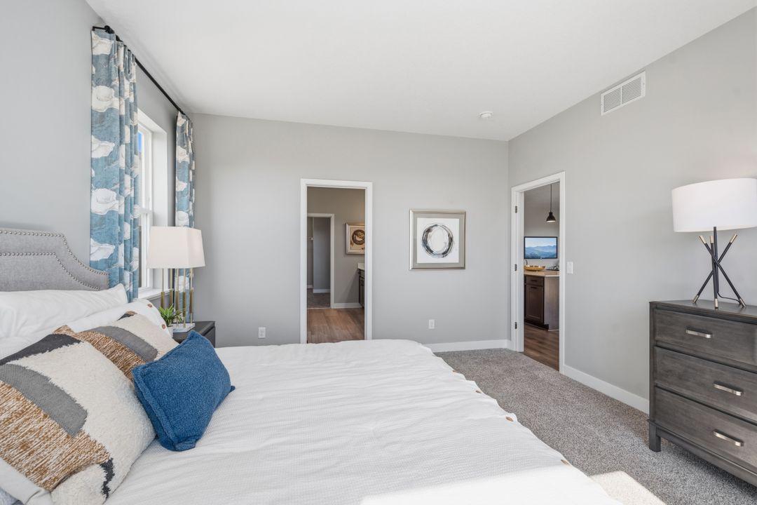 The spacious primary bedroom provides reprieve when wanted. Model photo, options and colors may vary.