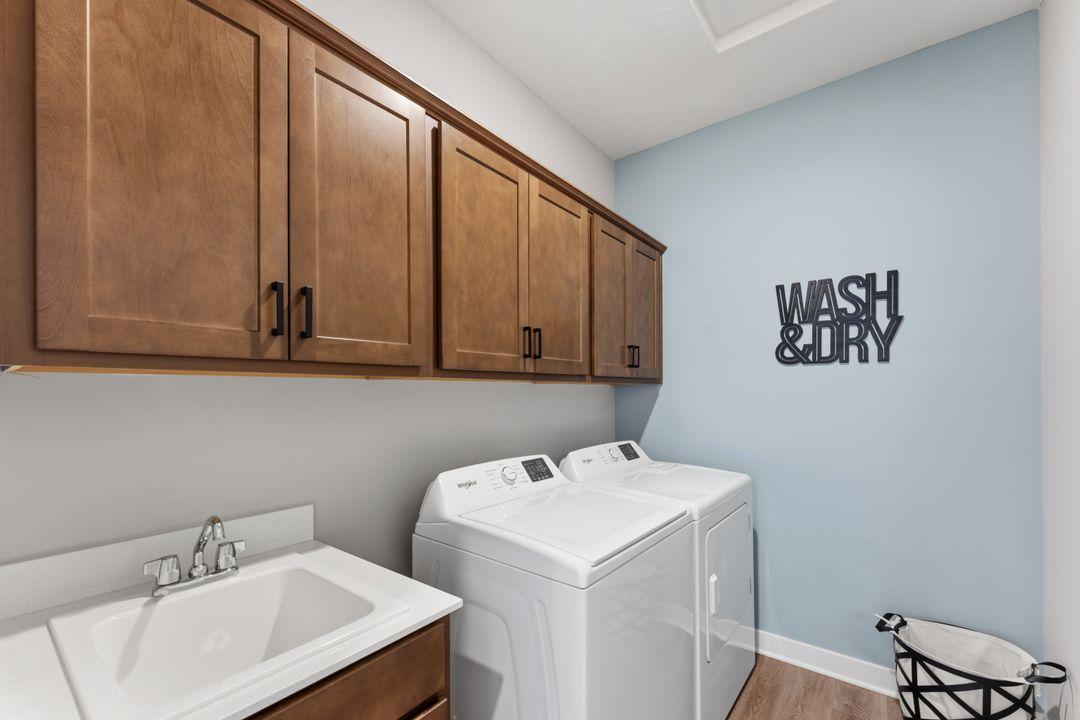 Laundry room outside the primary suite. Model photo, options and colors may vary.