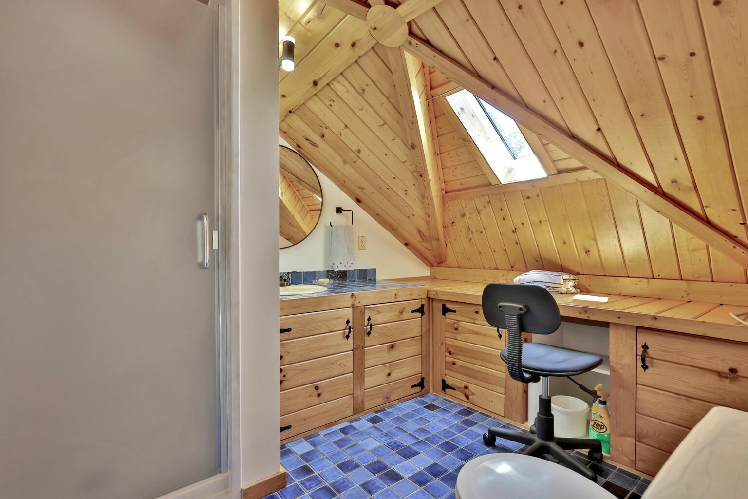 3/4 bath on the third level with a dressing table and tile floor.