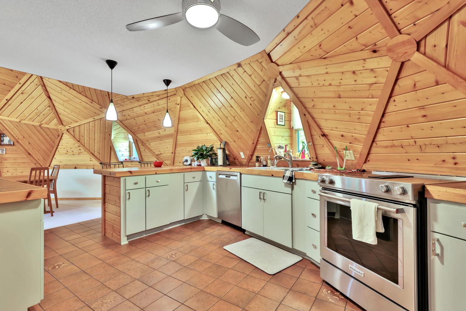 Spacious kitchen with stainless steel appliances, lots of counter space, and a tile floor.
