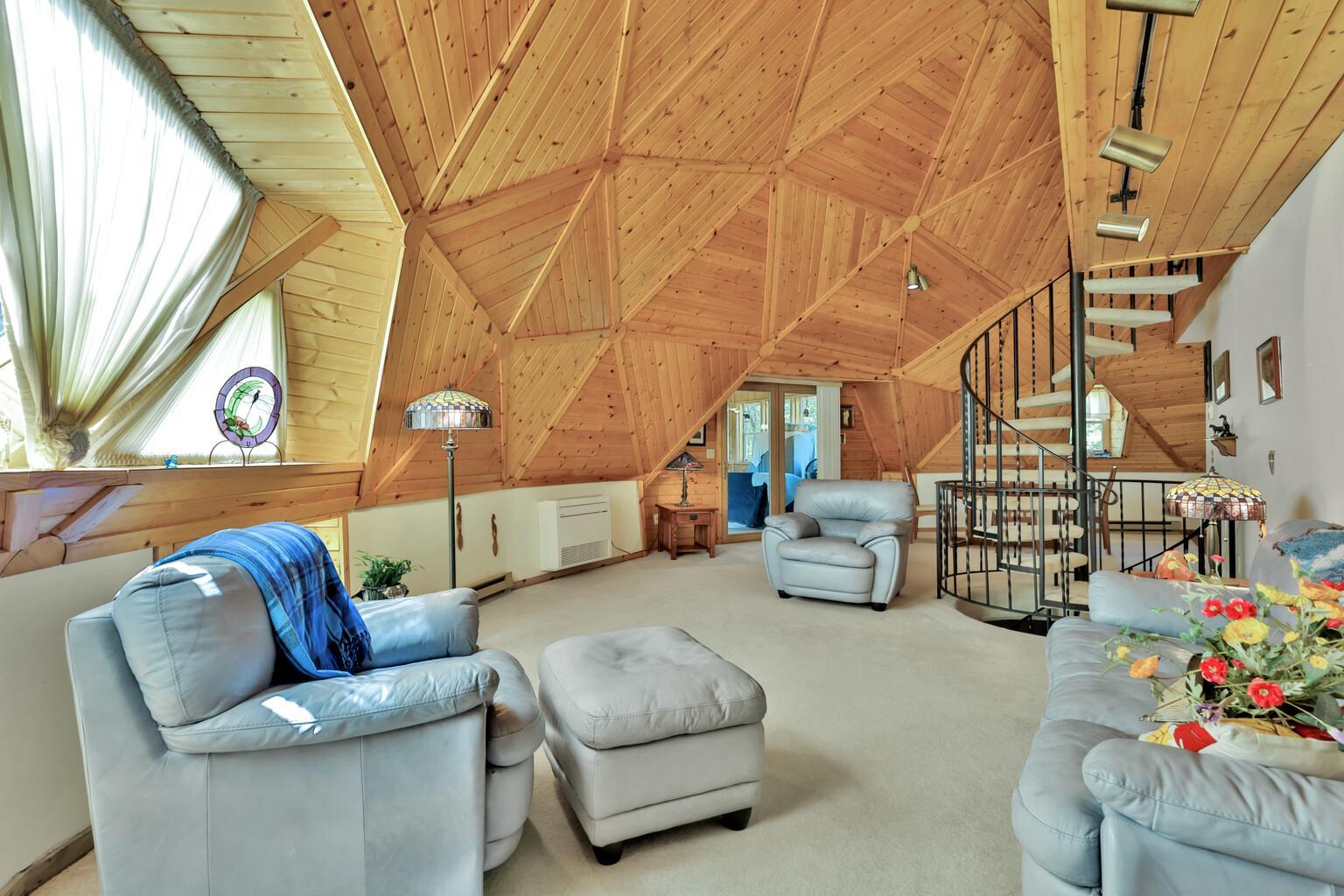 Main floor living room with spiral staircase up to the third level or down to the first level.