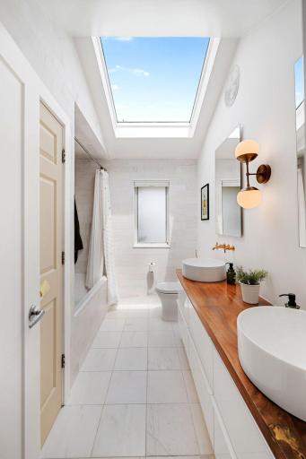 Showstopping main level full bathroom with skylight, linen storage, incredible double vanity & contemporary finishes.