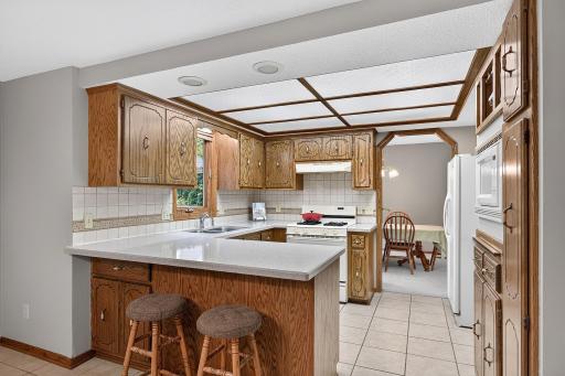 Kitchen with breakfast bar and solid surface countertops.