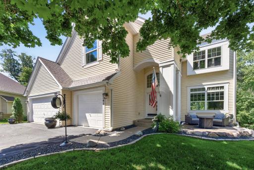 Stunning two-story exterior with mature trees, expansive driveway and 3-car garage.