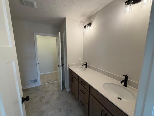 Dual vanity in the private en-suite bath provides maximum functionality. Features a large shower.