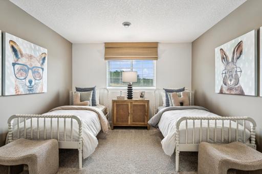 (Photo of a decorated model, actual homes finishes will vary) Lower-level bedroom.