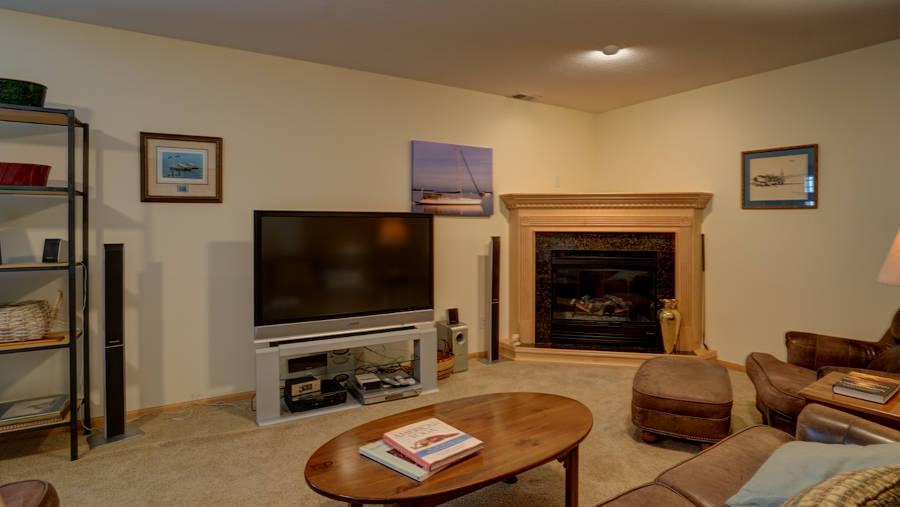A secondary corner gas fireplace, wrapped in deep dark granite and wood framing, anchors this incredible recreational space.