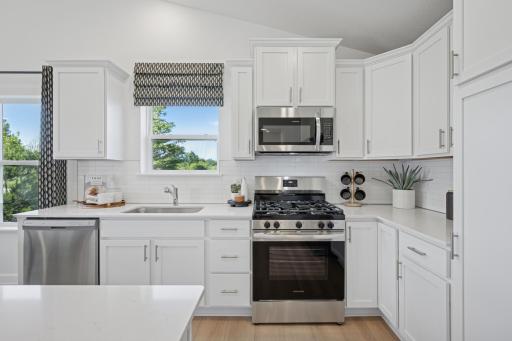 *Photo of model home, actual features may vary. This thoughtfully-designed kitchen layout features stainless steel appliances and quartz countertops.