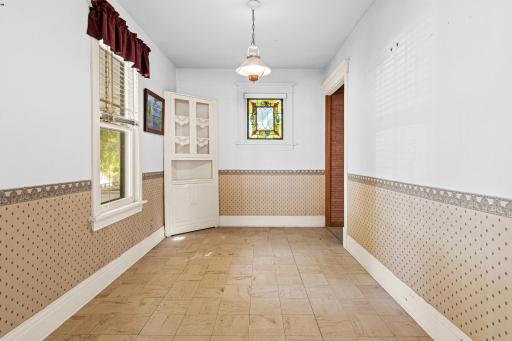 A stunning stained-glass window sets this dining room apart, casting colorful light across the space and offering a rare architectural detail full of history.