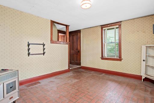 Sunlight pours through this basement room's window, highlighting the home's authentic period details and its potential for a beautiful refresh.