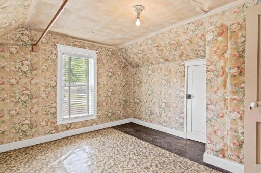Tucked beneath the home's classic roofline, this upper-level bedroom offers cozy proportions and natural light making it an ideal space to reimagine with your personal style.