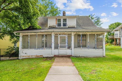 This inviting screened porch is a classic feature of the era, ready to be restored into a favorite gathering spot overlooking the tree-lined street.