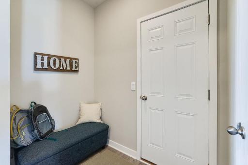 Walk into the mud room from the 3-car garage. Includes space for bench or your built in cubbies. Large closet shown to the right. Photo of model home, colors and finishes will vary.