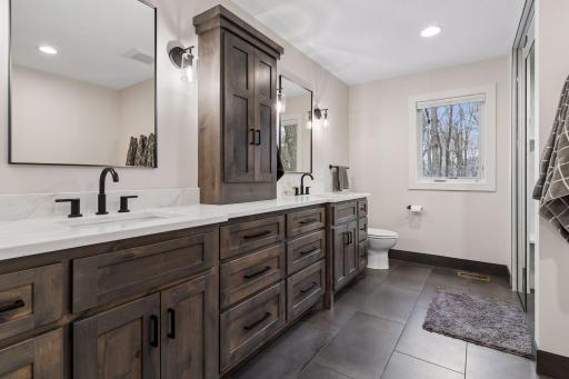 Large primary bathroom with steam shower, heated floors and standalone soaking tub.